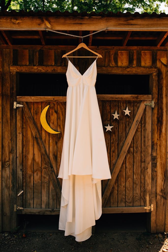 Wedding dress hanging in front of wooden building