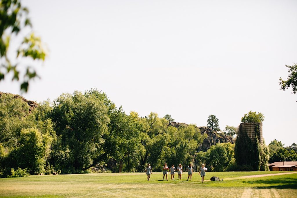 Bridal party walking across the fields of Planet Bluegrass