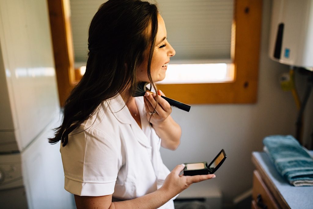 Bride applying makeup before her wedding day