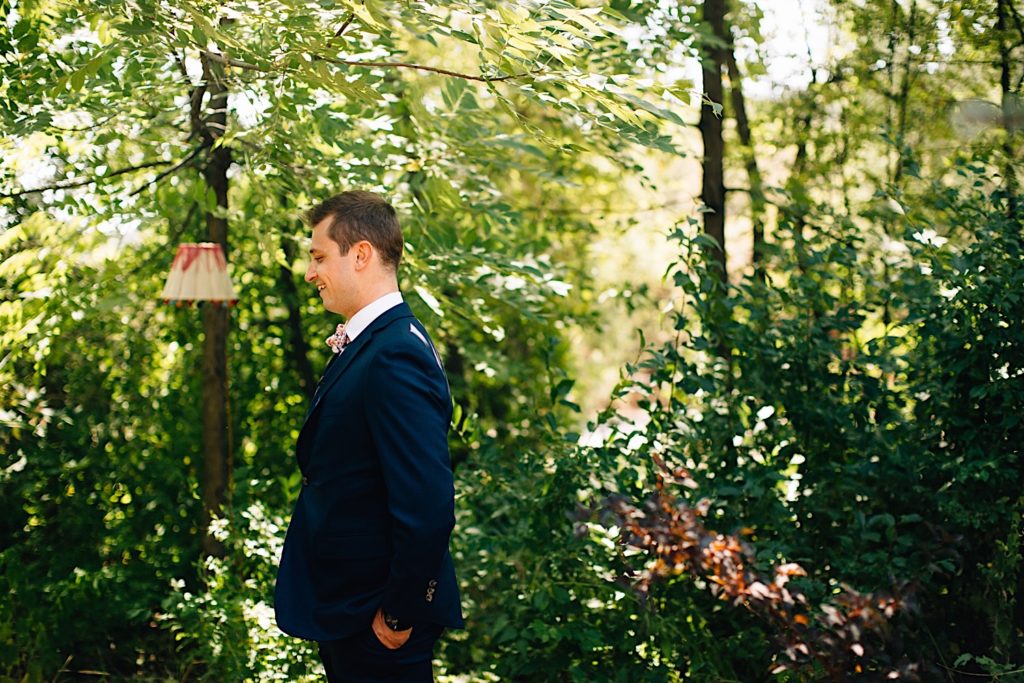 Side profile of groom in front of greenery at Planet Bluegrass