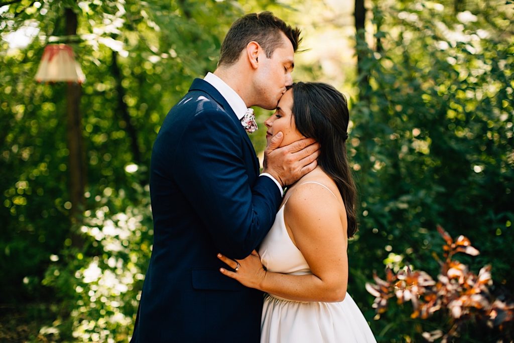 Groom kisses bride on the forehead