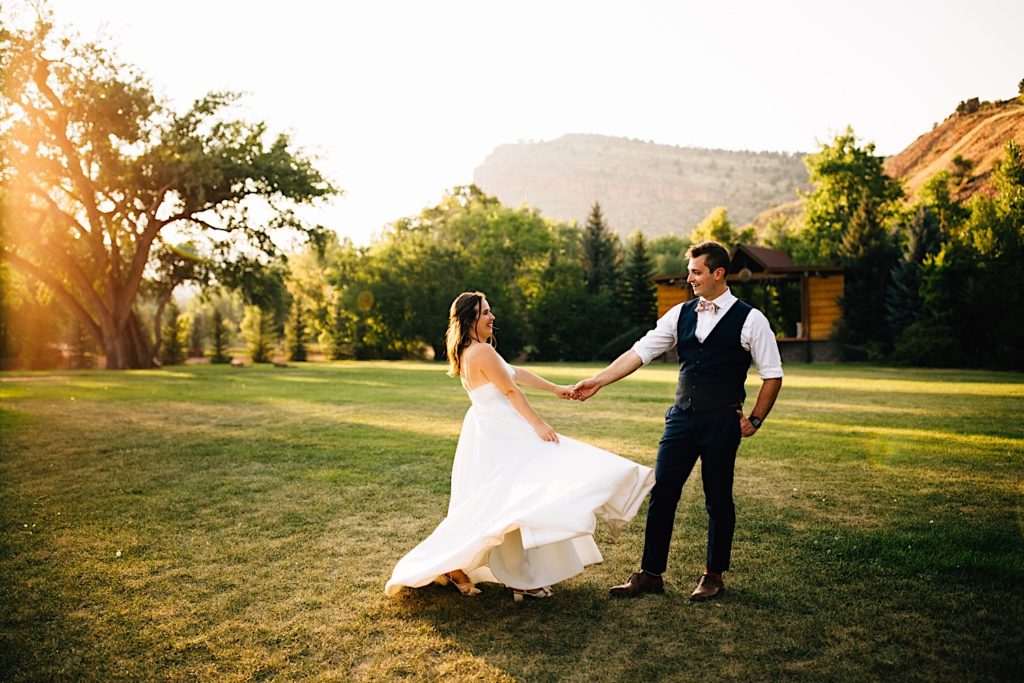 Bride and groom dance with each other in a field at Planet Bluegrass after their wedding ceremony