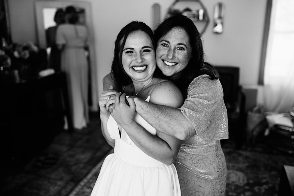 Black and white photo of a mother hugging her daughter on her wedding day