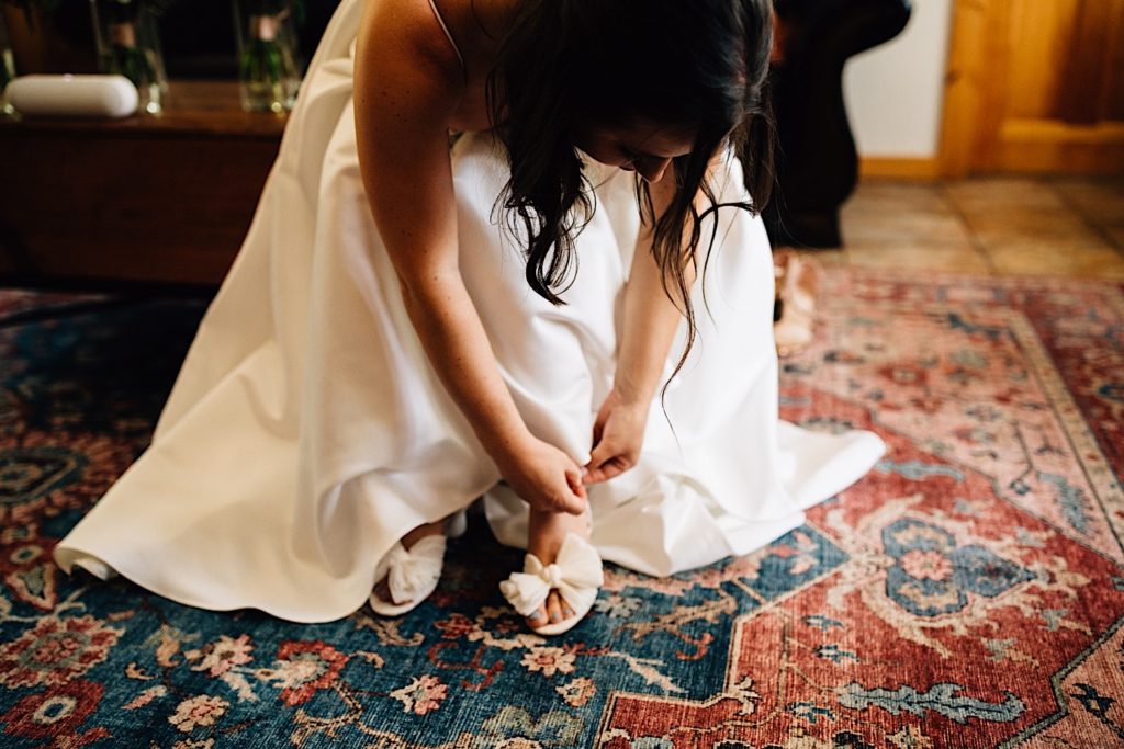 Bride adjusting her shoes while in her wedding dress
