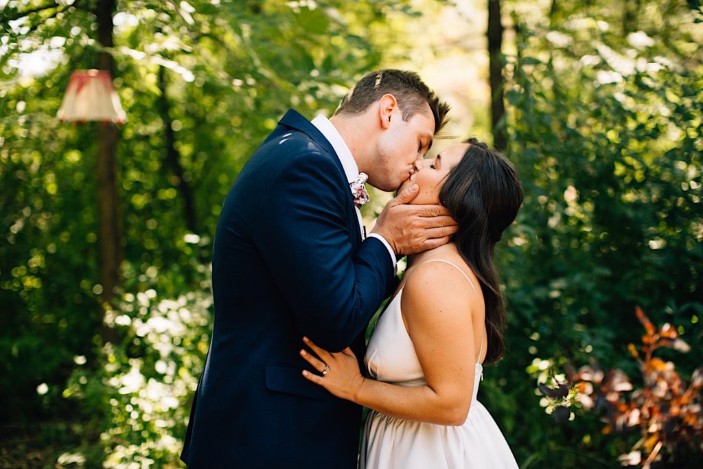 Bride and groom kiss while holding eachother