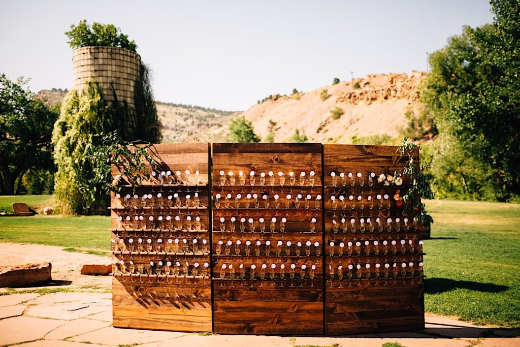 Three wooden boards with rows of numbered champagne glasses on them