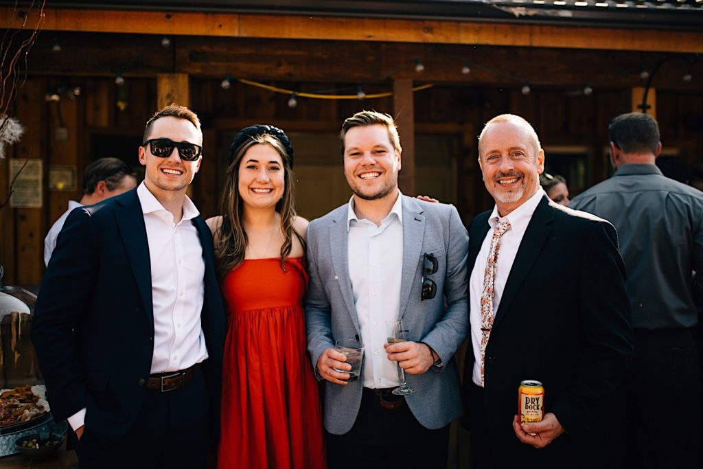 Guests at a wedding at Planet Bluegrass smile at the camera while holding drinks