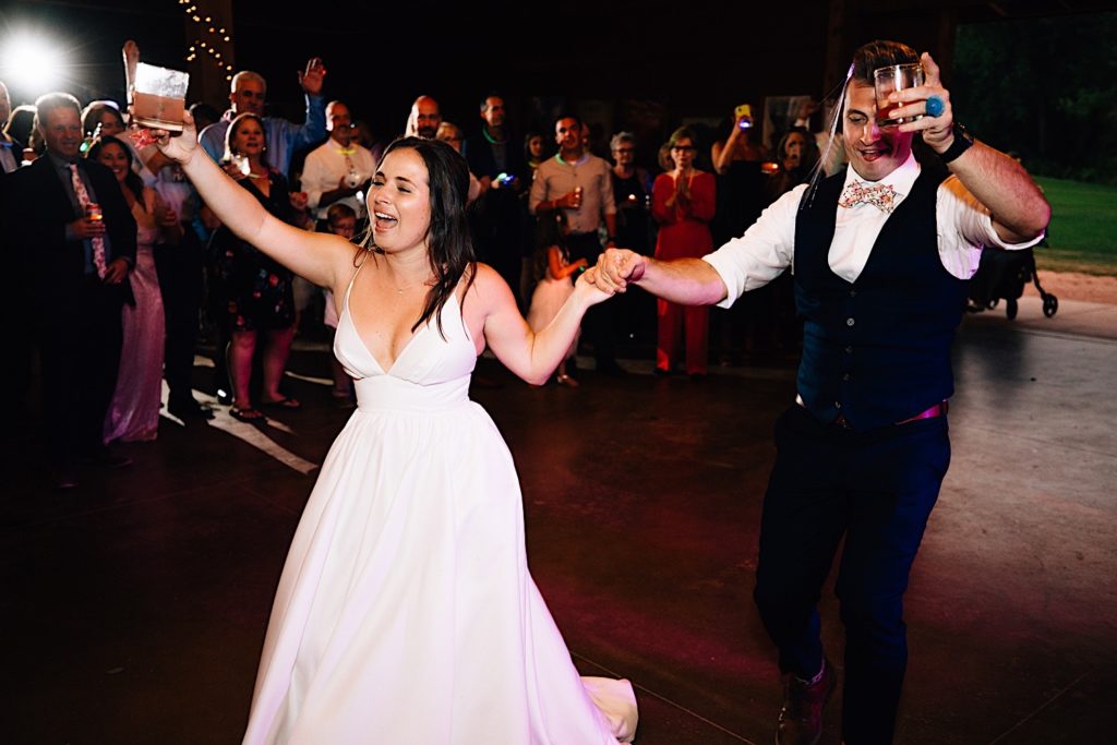 Bride and groom enter the dance floor surrounded by their guests at their Planet Bluegrass wedding reception
