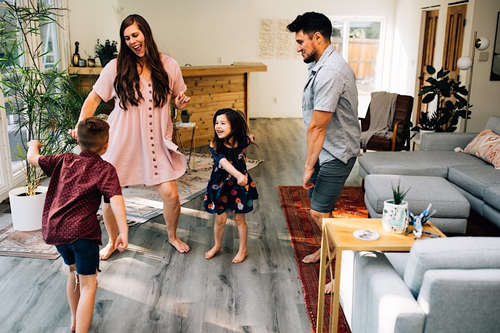 A family dance together in their home's living room
