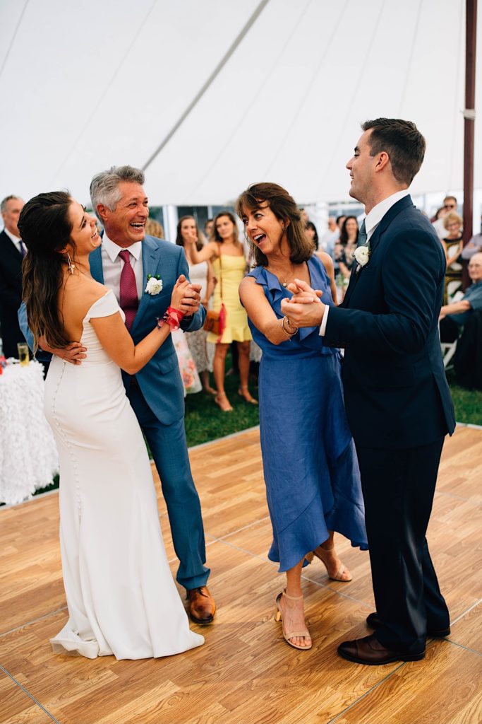 A bride and her father dance alongside the groom and his mother during their Cape Cod wedding reception.