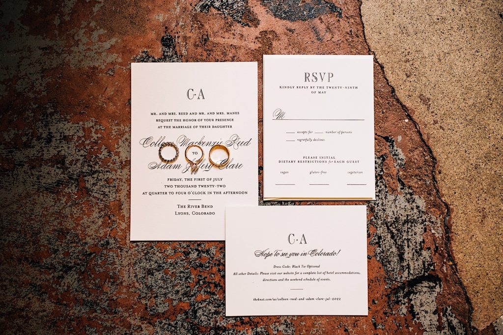 Classic wedding flat lay for bride and grooms wedding in Colorado.  The invitations and wedding rings are placed on red rocks outside the venue.