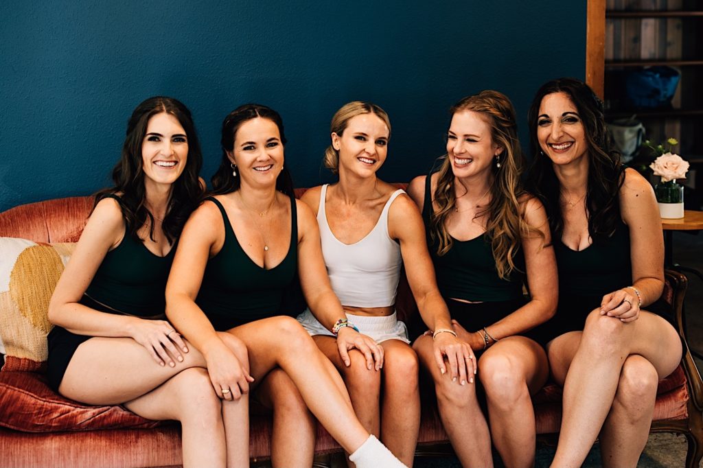 Bride and her bridal party wear active wear for their getting ready outfits.  The bride wears white while her bridesmaids wear black.