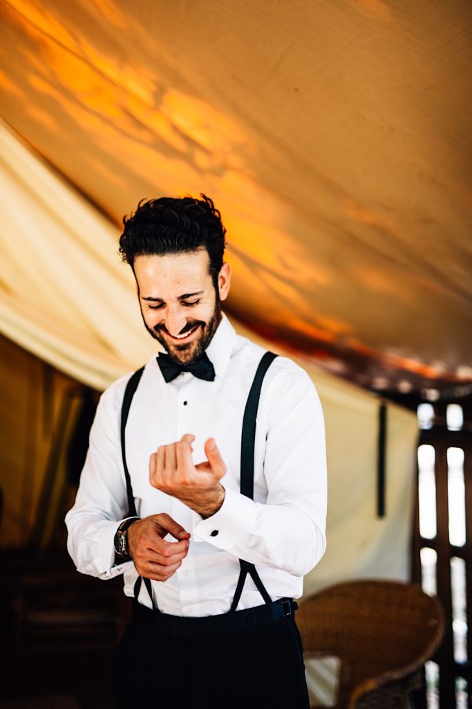 Groom smiles while putting on the final touches the morning of his wedding