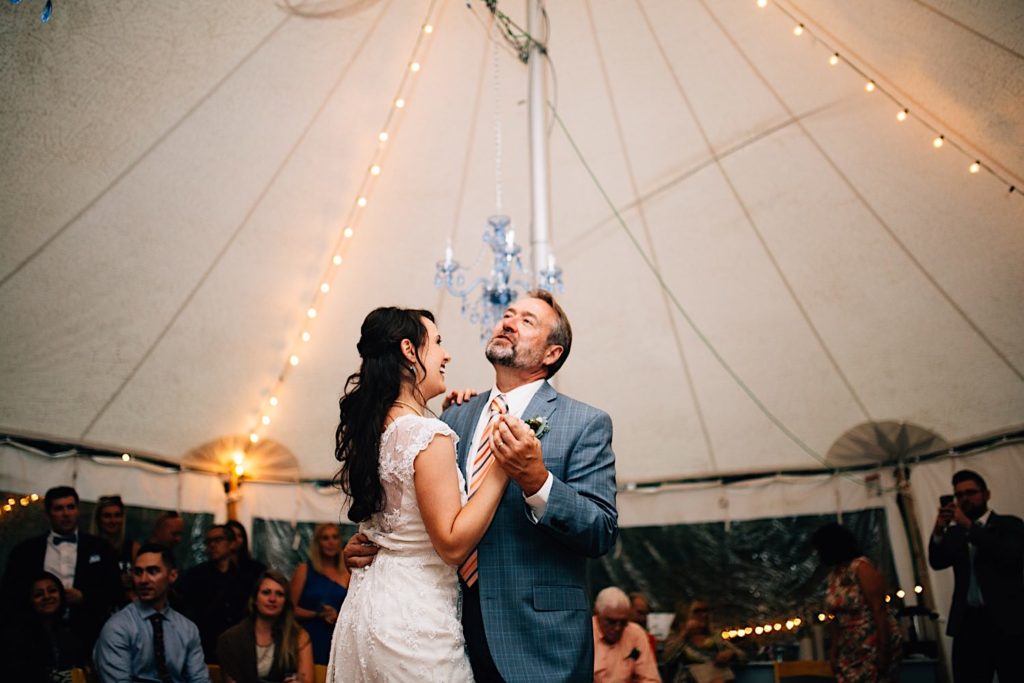 A bride dances with her dad during her wedding reception in the tent at Lyons Farmette in Colorado.