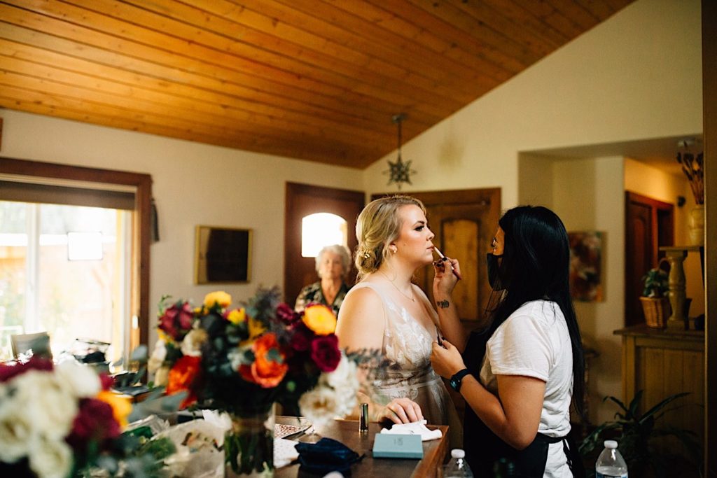A bride gets her makeup touched up in the getting ready space at Lyons Farmette.